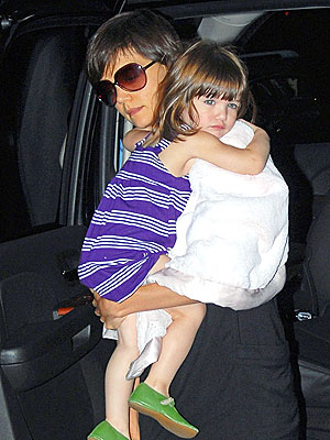 Katie Holmes keeps a tight hold of Suri, 2, Wednesday as the mother-daughter 